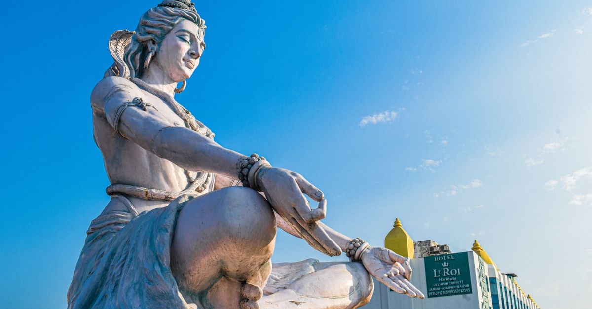 Maan Hotel in Haridwar: A Steps-From-Ghat Stay Magnificent low-angle view of Lord Shiva statue against a blue sky in Haridwar, India.