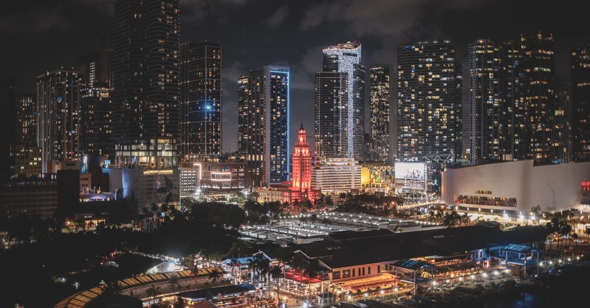 Hôtel Gloria in Mbuji-Mayi: Avenue Lusambo Stay With a Poolside Pulse Vibrant Miami downtown skyline at night with illuminated skyscrapers and busy city vibes.