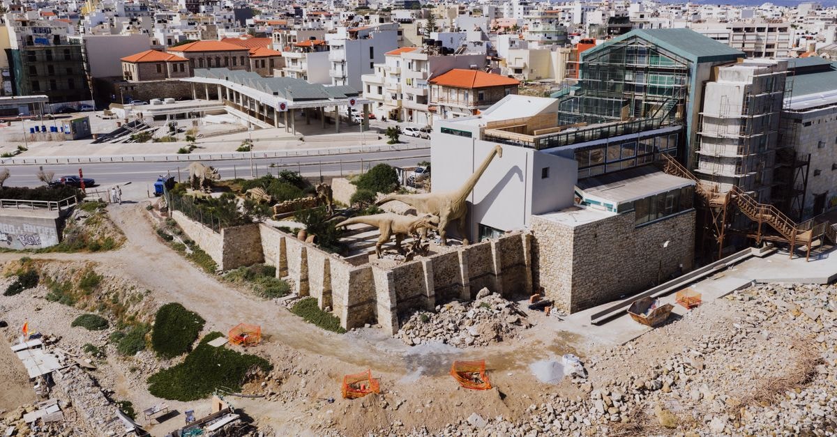 Aerial shot of Heraklion Natural History Museum showcasing dinosaur models and urban landscape.