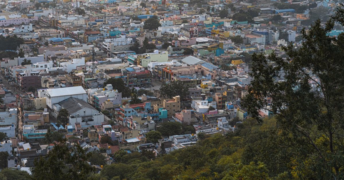 Hotel Regalia in Tirupati: A Quiet Base Near Seshachala Hills Panoramic aerial view of Tiruvannamalai's colorful urban landscape surrounded by greenery.