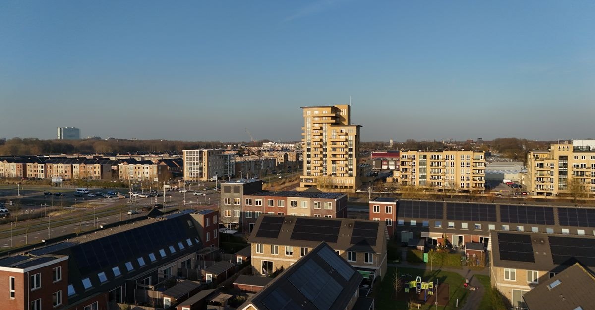 Leonardo Hotel Lelystad City Center: A Monochrome Base Near Station and Nature Drone capture of a modern residential area in Nederland showcasing apartment buildings and solar rooftops.