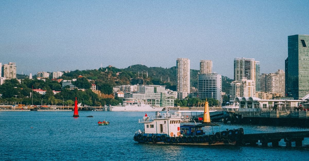 Scenic view of a vibrant coastal city with modern skyscrapers and bustling harbor.