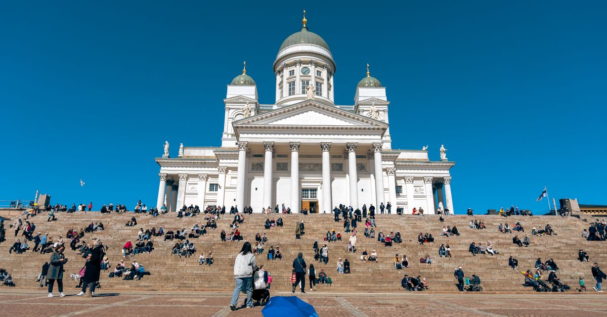Helsinki travel guide for July 2026: events, weather and practical tips People gather on the steps of Helsinki Cathedral under a bright blue sky, showcasing Finland's iconic architecture.