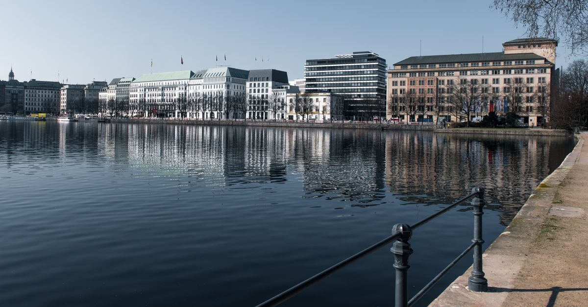 Slow mornings by the Alster: a thoughtful Hamburg travel guide Beautiful reflection of Hamburg's architecture on the Alster Lake during the day.