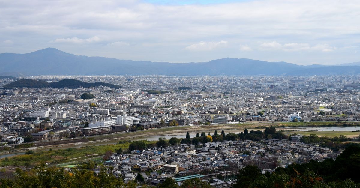 Noria Hotel in Hama: Central Stay Near the Norias An expansive aerial view of Kyoto cityscape, framed by distant mountains and rivers.