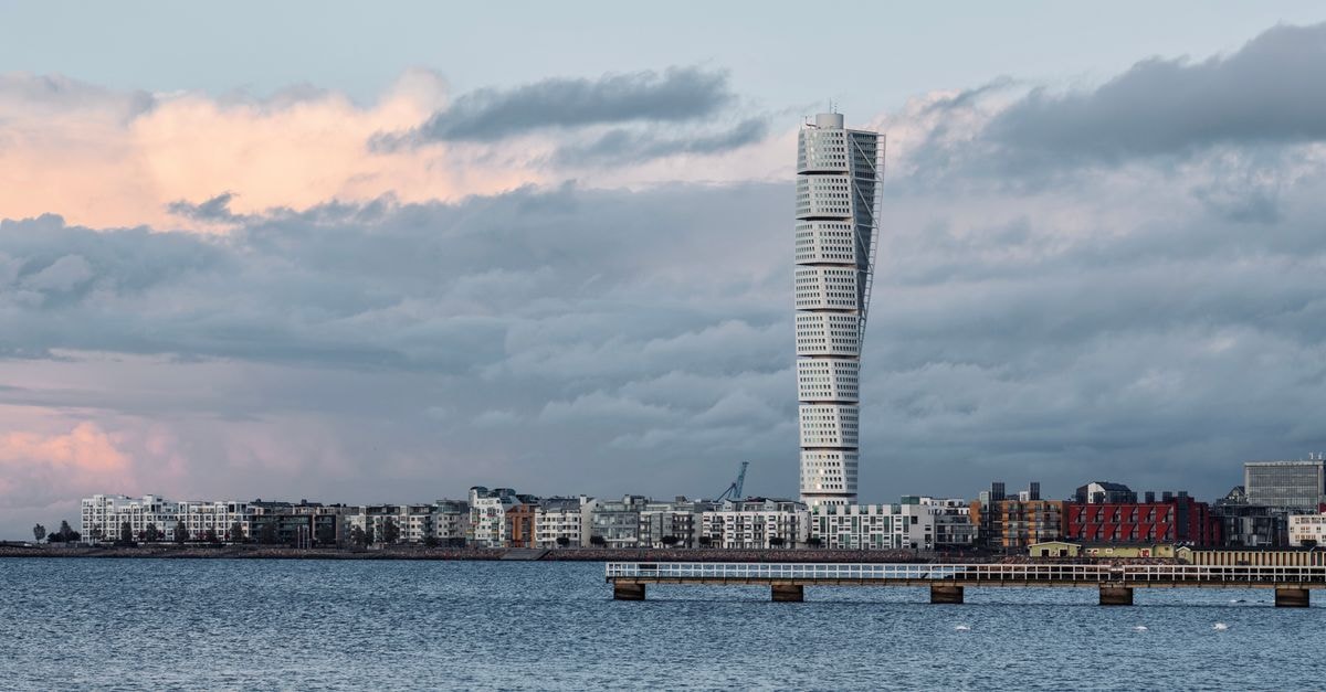 A stunning view of Malmö cityscape featuring the iconic Turning Torso under a cloudy sky.