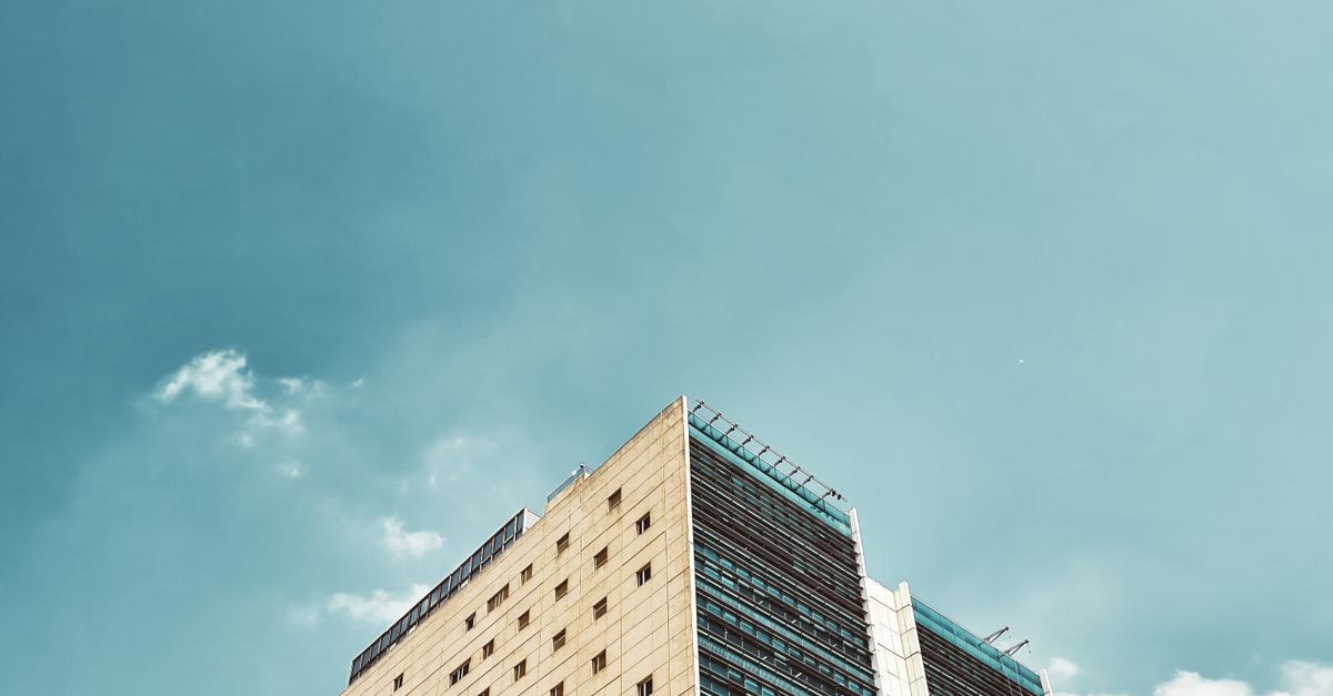 Tall modern office building with clear blue sky, showcasing urban architecture and minimalist design.