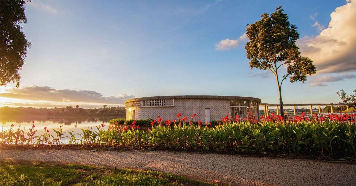 San Marco Hotel in Brasília: A 1984 Landmark on Hotel Sector South Beautiful sunset at Pampulha Lake with architectural building and lush gardens.