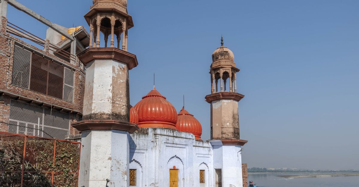 Muzaffarnagar Travel Guide: What to Know Before You Go Old temple with red domes and towers by the Yamuna River in Mathura, India.