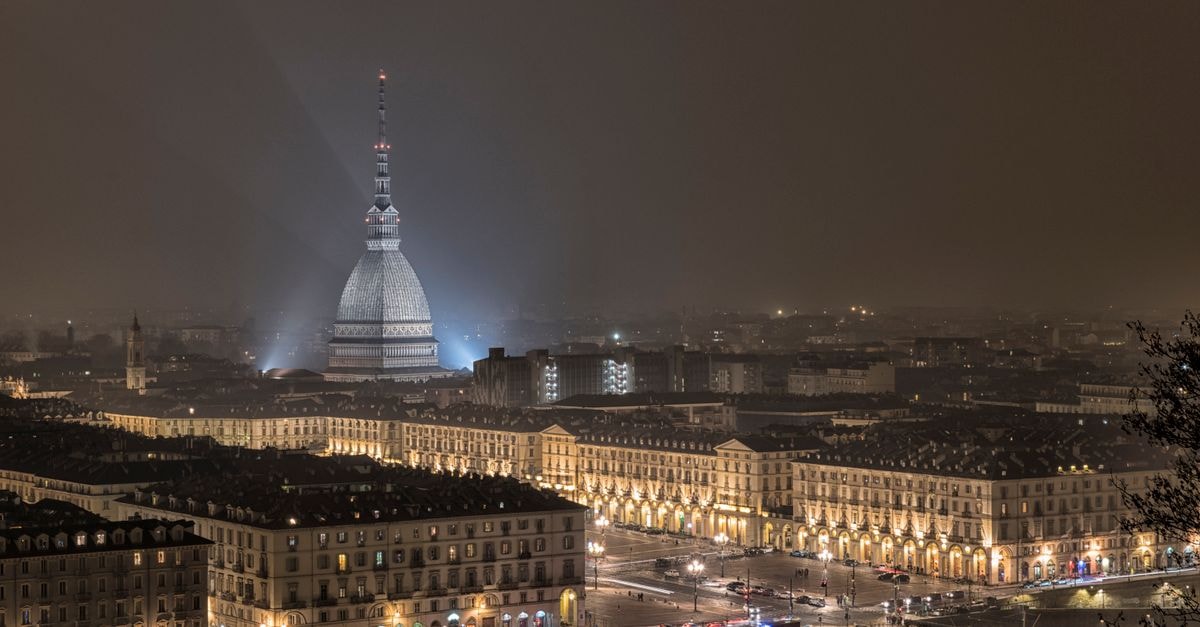 NH Collection Piazza Carlina, Turin — A 17th-Century Courtyard Stay Stunning night view of Torino cityscape featuring Mole Antonelliana illuminated amidst historical buildings.