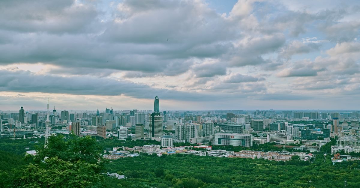 Yongqing Inn, Xinzhou: A Calm Pocket Near the City Hospital of Traditional Chinese Medicine A stunning cityscape with lush greenery in the foreground under a partly cloudy sky.
