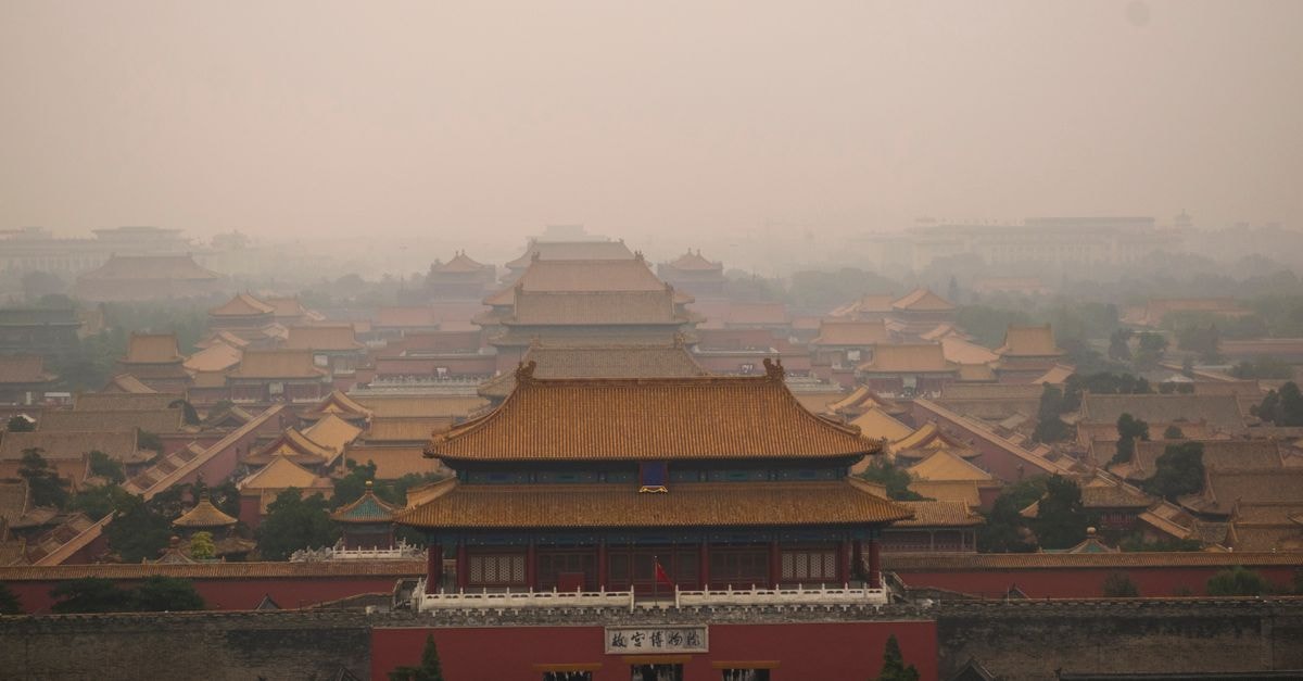 Qufu Travel Guide: Slow Days in the Holy City of the East A hazy aerial view of the historic Forbidden City in Beijing, China with traditional Chinese architecture.
