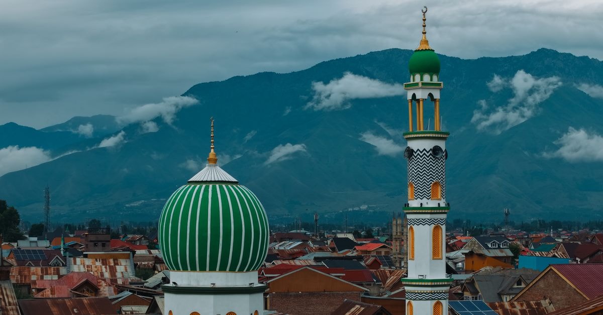 Medan Travel Guide: Temples, Mosques and a Food-Lover's Doorstep Aerial view of a striking mosque in Srinagar, surrounded by mountains and cloudy skies.