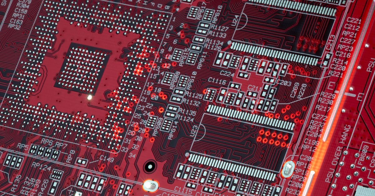 Tower Semiconductor climbs on Nvidia silicon photonics deal for AI data centers Detailed shot of a red motherboard showcasing electronic components and circuits.