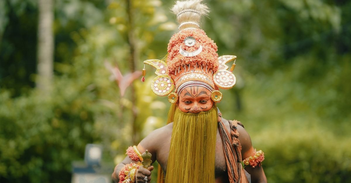 Theyam performer in elaborate costume and makeup, Kozhikode, Kerala, India.