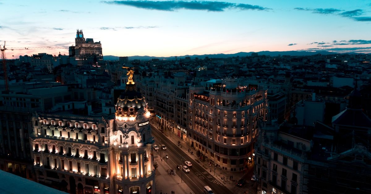 Petit Palace Puerta del Sol, Madrid — A 19th-Century Façade in the Heart of the City A stunning view of Madrid cityscape during twilight with beautifully illuminated buildings and clear skies.