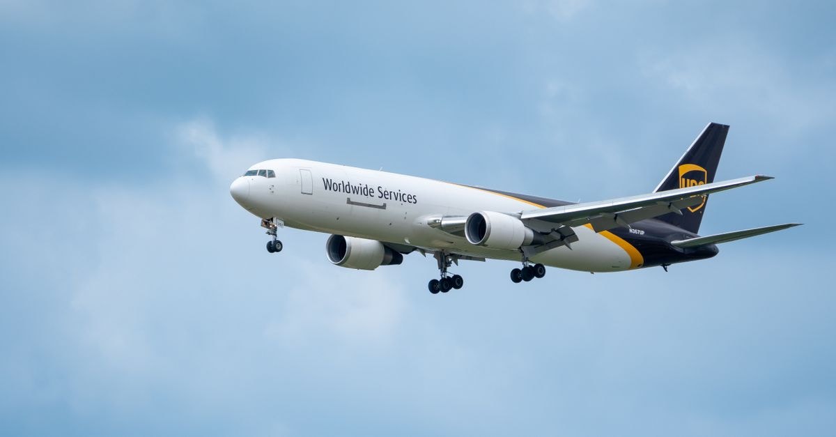 Allegiant Travel: Acquisition Math Meets a Levered Balance Sheet A commercial airplane branded as Worldwide Services flying against a backdrop of a blue sky with clouds.