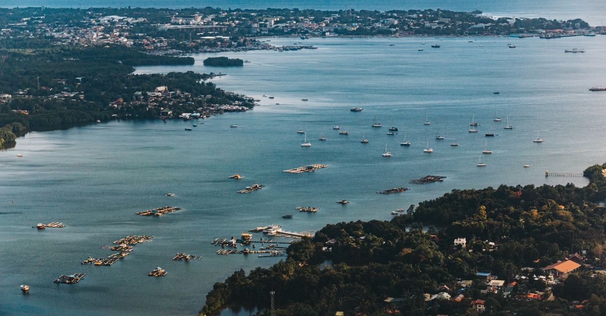 Scenic aerial view of a coastal town with boats and lush greenery, perfect for travel and nature themes.