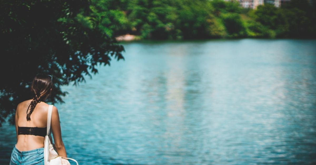 A woman enjoys a sunny day by the serene Lady Bird Lake in Austin, Texas.