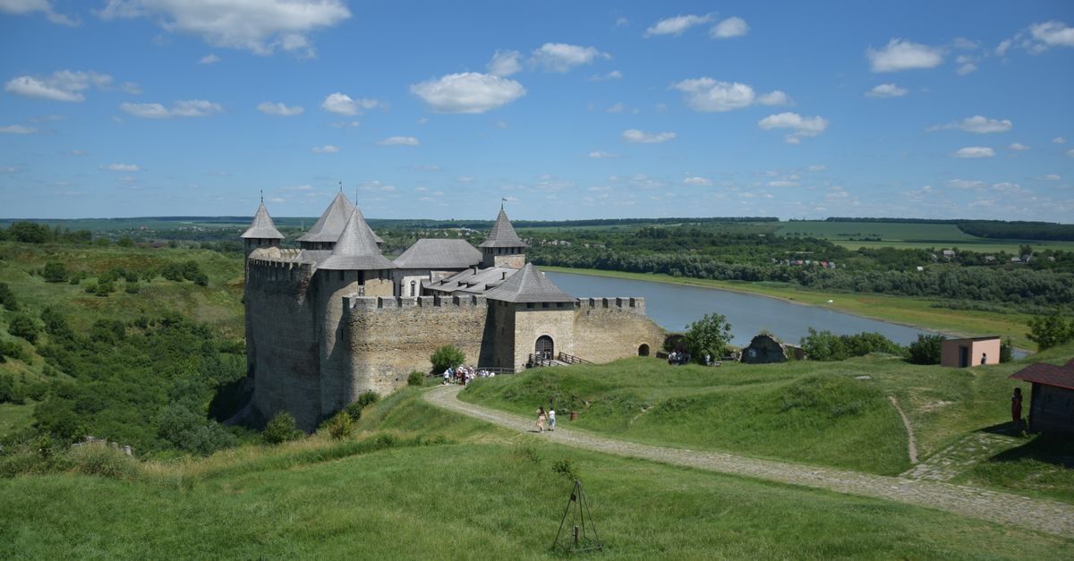 Stunning view of a medieval fortress under a clear blue sky beside a winding river.