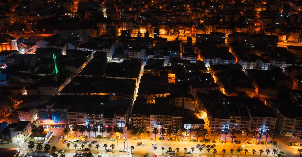 ORZU Hotel in Namangan: A Garden Stay on Nodira Street A stunning aerial view showcasing vibrant city streets illuminated at night with vivid lights.