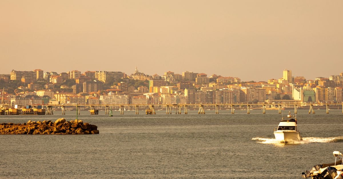 Hotel Dorma Coliseum, Santander — Plaza de los Remedios Address A charming coastal cityscape with a boat cruising on calm waters at sunset.