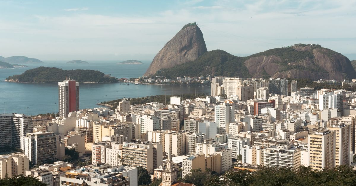 Ibis Rio de Janeiro Centro in Rio de Janeiro: A Lapa-Adjacent Base for the Cidade Maravilhosa Stunning aerial view of Rio de Janeiro with Sugarloaf Mountain and urban landscape under a clear blue sky.