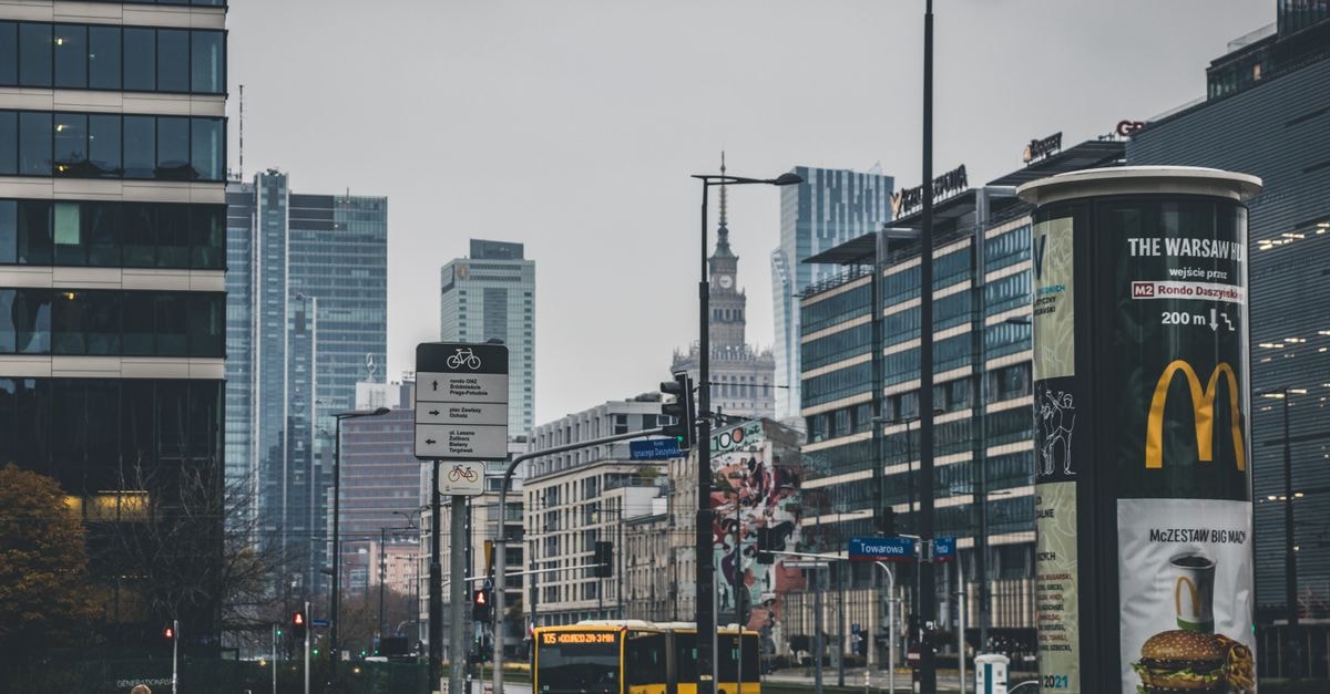 Modern cityscape of Warsaw, showcasing urban architecture and transportation on a cloudy day.