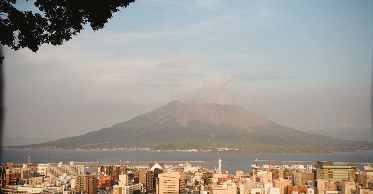 Kagoshima Travel Guide: Planning Tips, Costs and Things to Do Dramatic view of Kagoshima cityscape with Sakurajima volcano in Japan.