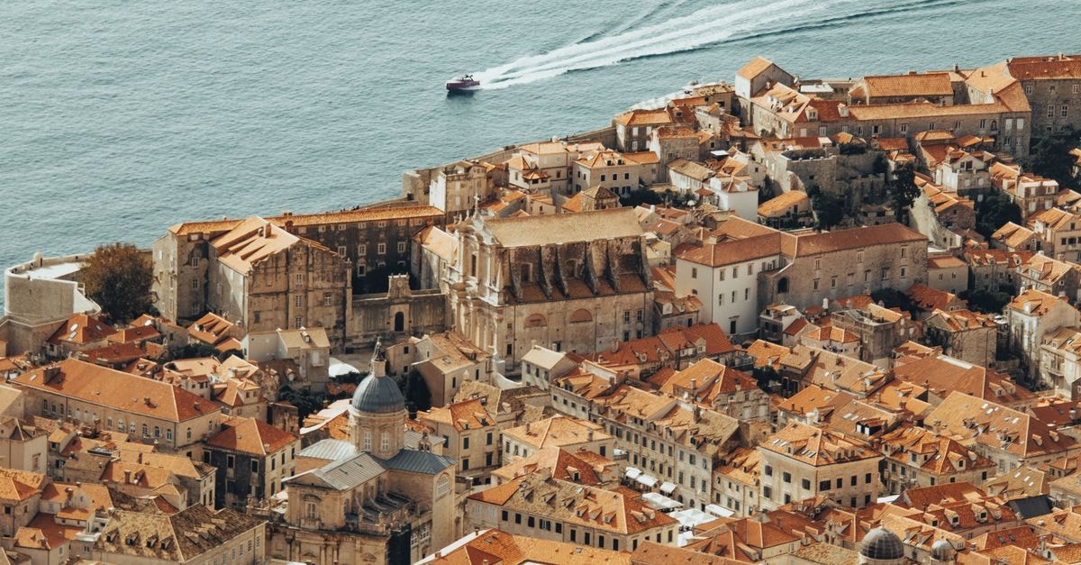 Aerial shot of Dubrovnik's Old Town featuring ancient architecture and the Adriatic Sea.