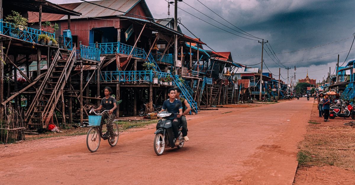 Bicycles and scooters navigate through Kampong Phluk's stilt house village.