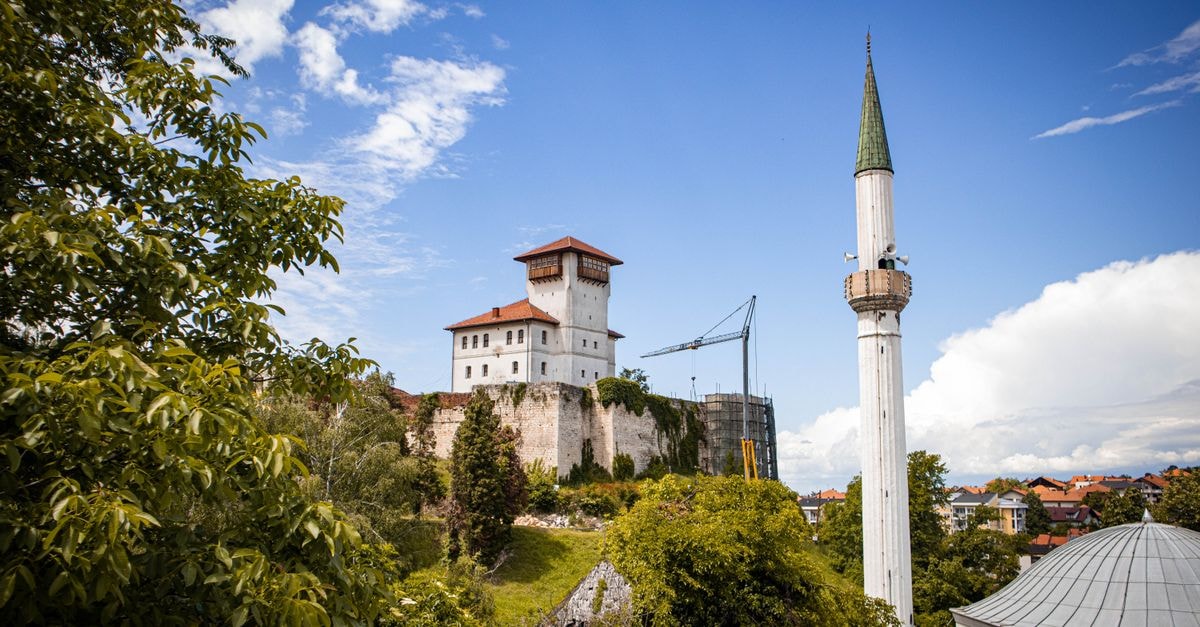 Slatina Travel Guide: Planning Tips, Costs and Things to Do A stunning view of Gradačac Castle and minaret surrounded by lush greenery under a bright blue sky.