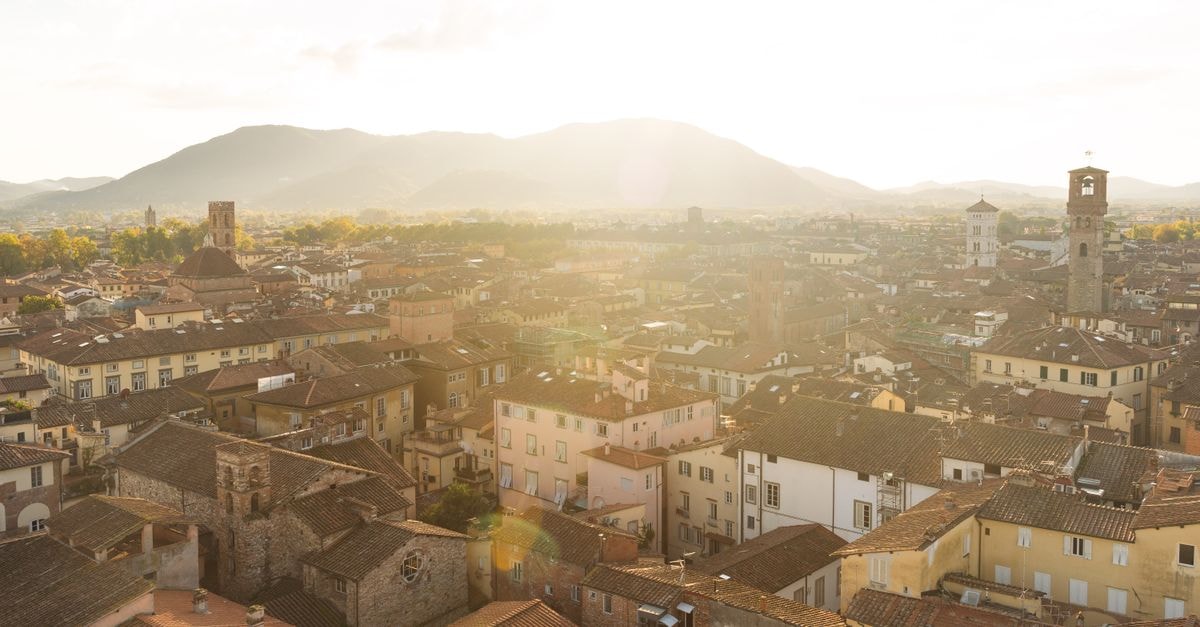 A picturesque aerial view of Lucca's historic rooftops at sunset, showcasing its architectural beauty.