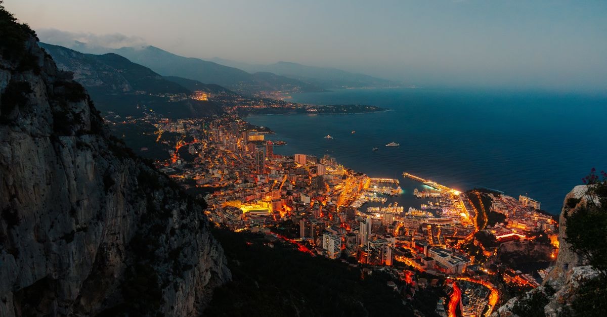 Stunning aerial perspective of Monaco's illuminated harbor and cityscape at twilight.