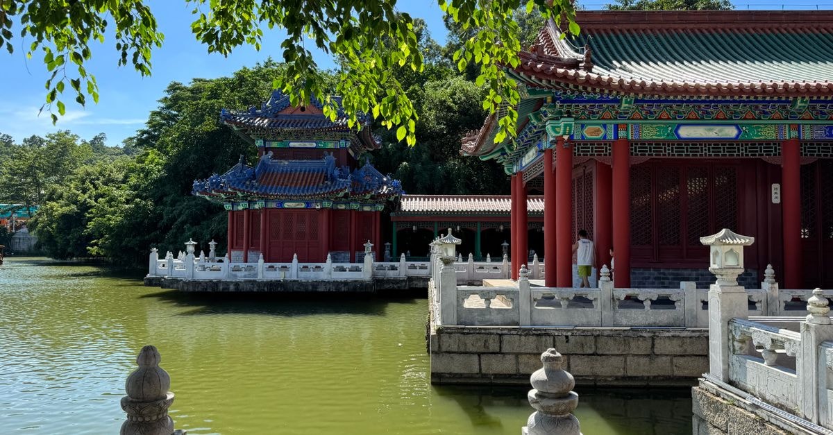 Anyang travel guide: budgeting a Henan heritage city like a creator Stunning traditional Chinese pavilion with intricate roof, beside a tranquil pond surrounded by lush greenery.