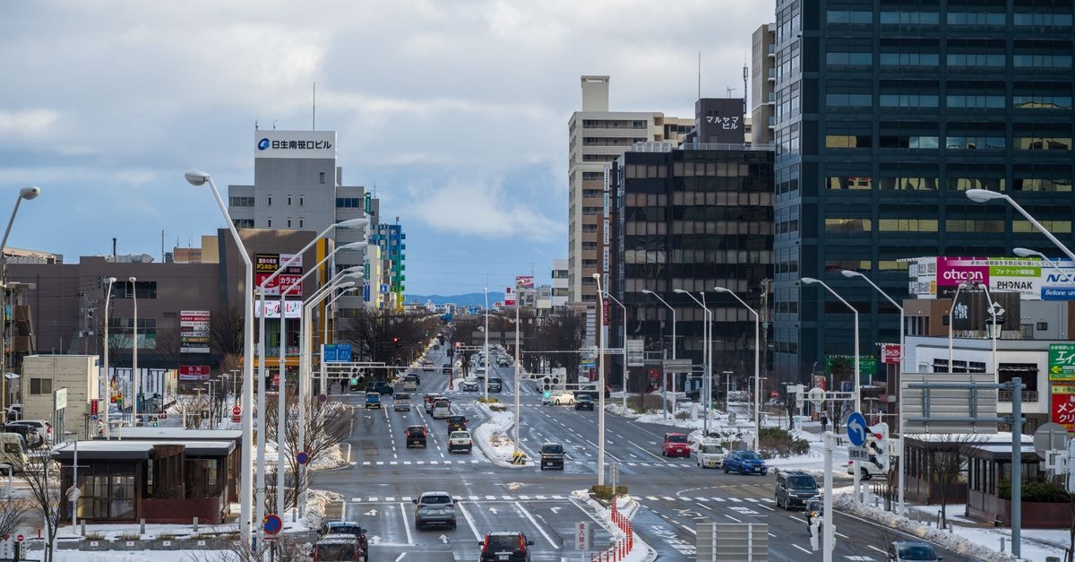 Asahikawa Travel Guide: Hokkaido's Northern Hub for Zoo, Ramen, and Mountain Day Trips A bustling city street in winter with cars and buildings lined with snow.