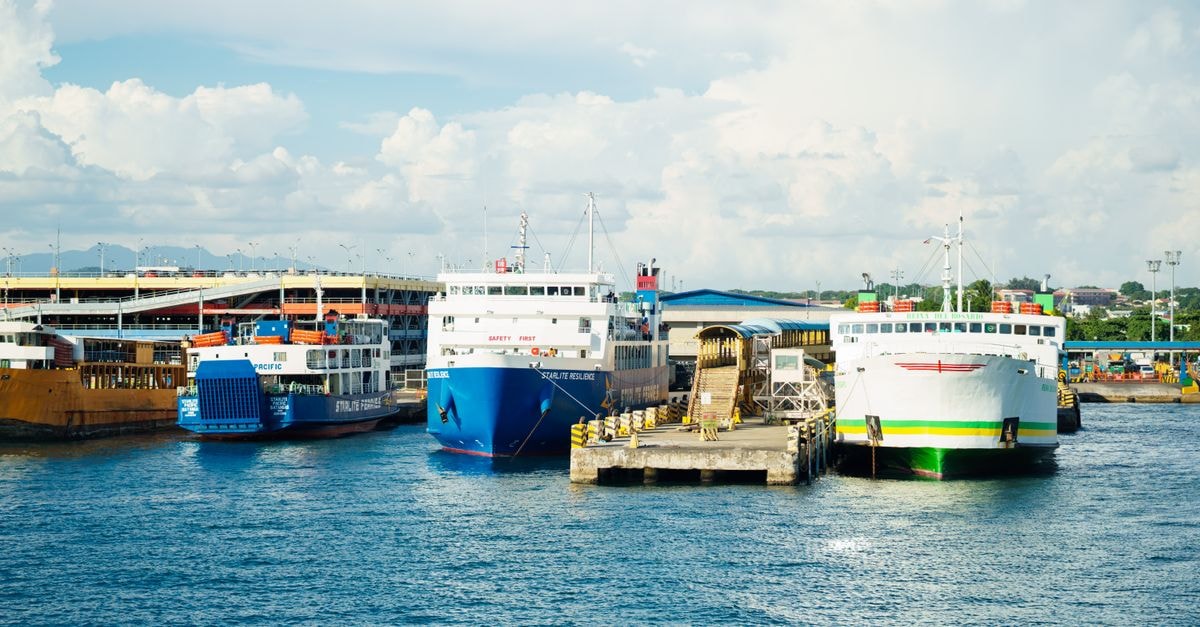 Vibrant ferries docked at a busy port under clear skies, showcasing maritime activity.