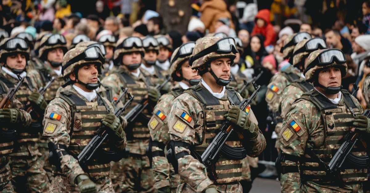Lockheed Martin unveils AIM-260 missile, signs Pentagon production deal Soldiers in uniform march during a military parade featuring diverse troops and spectators.