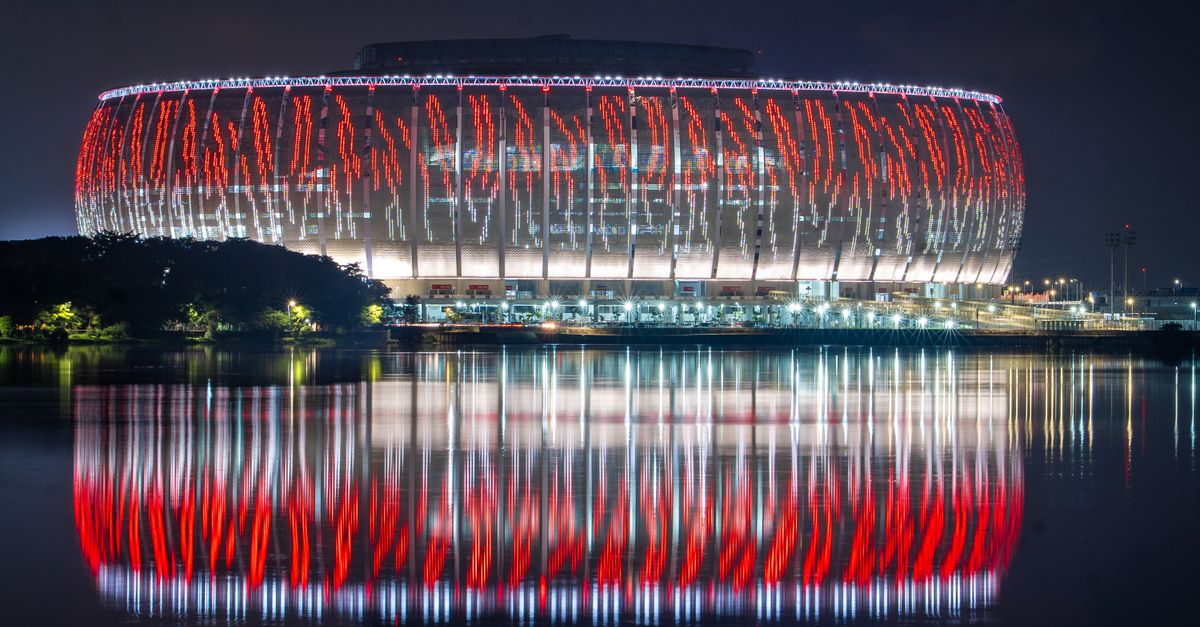Lusail Stadium beautifully illuminated with reflections on water during night in Qatar.