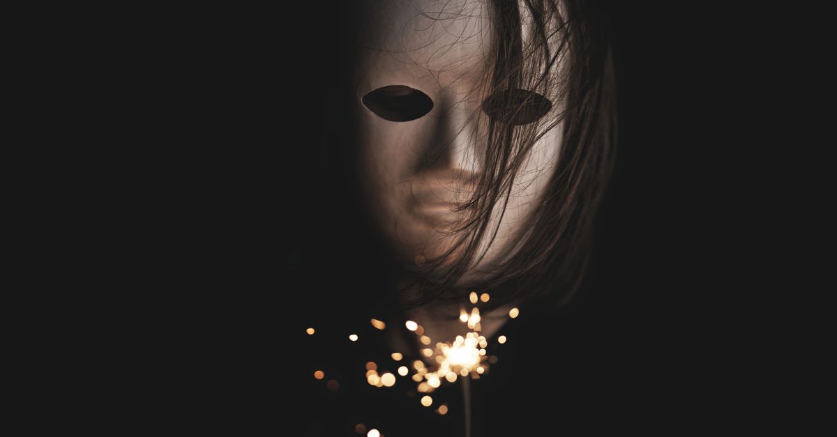 Jim Lee turned down $75,000 Masked Singer offer over meme fears A mysterious and eerie scene of a mask with a sparkler, set against a dark background, creating a haunting ambiance.