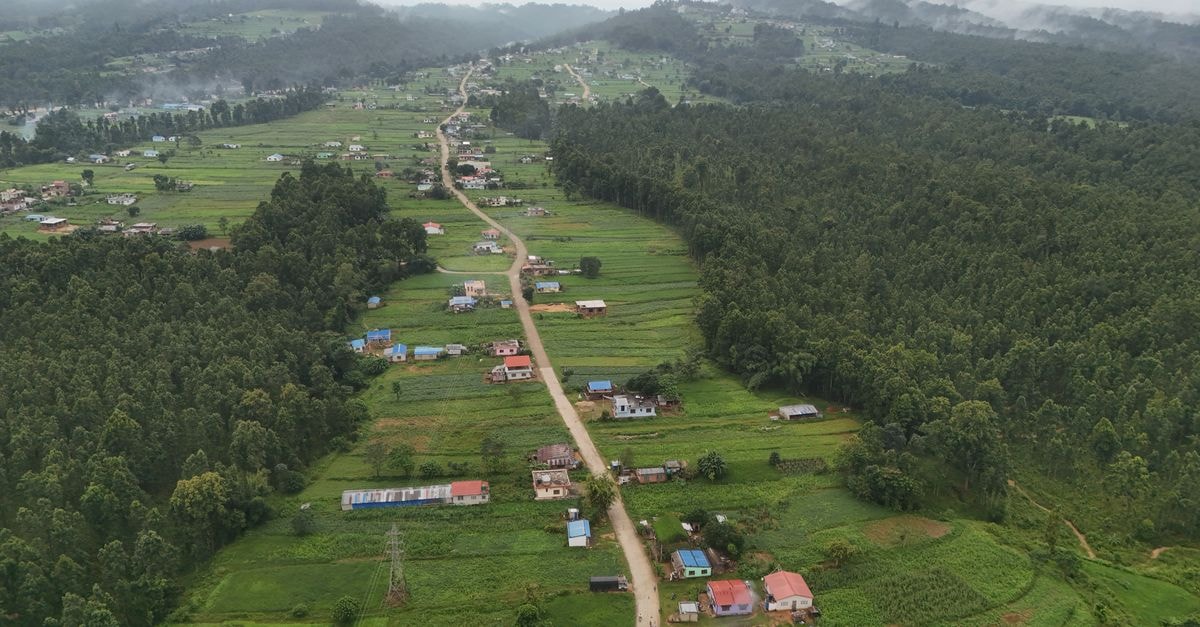 Stunning aerial vista of a verdant valley with scattered homes and dense forests in Nepal.