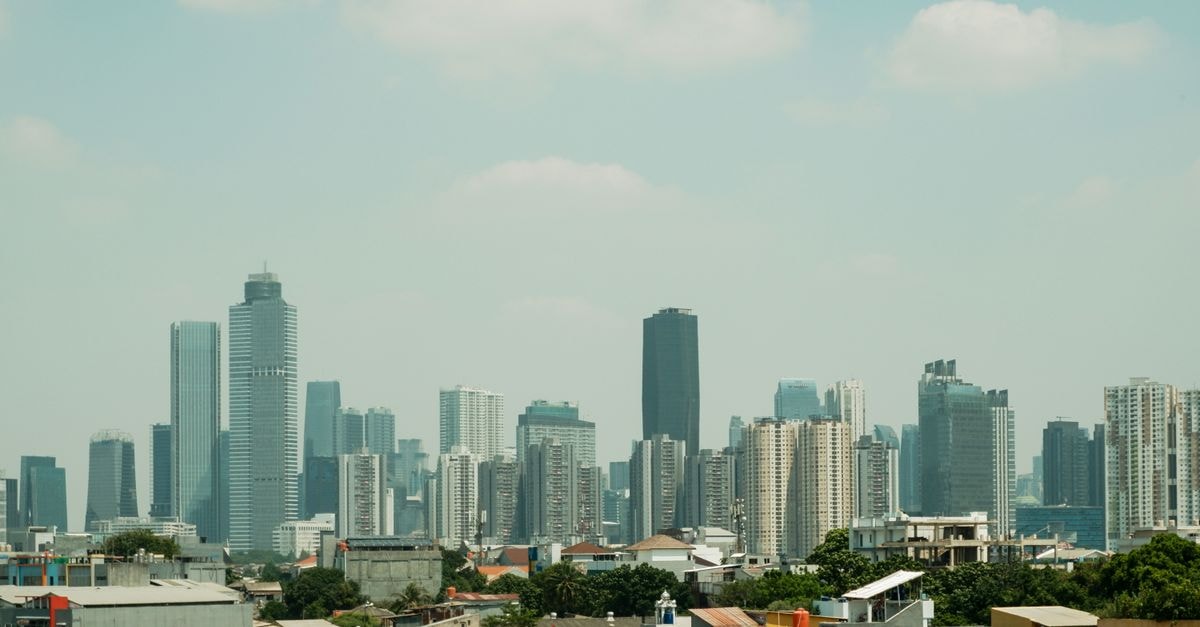 Ibis Styles Bekasi Jatibening, Bekasi — A Vibrant Homey Stay Explore the vibrant skyline of Jakarta with modern skyscrapers under a clear blue sky.