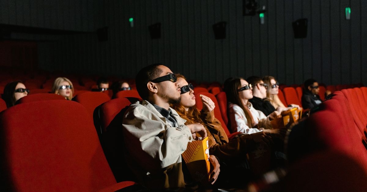 Spider-Man: Brand New Day tops the North American box office and clears $700 million domestically People watching a 3D movie in a theater, with popcorn in hand, fully immersed.