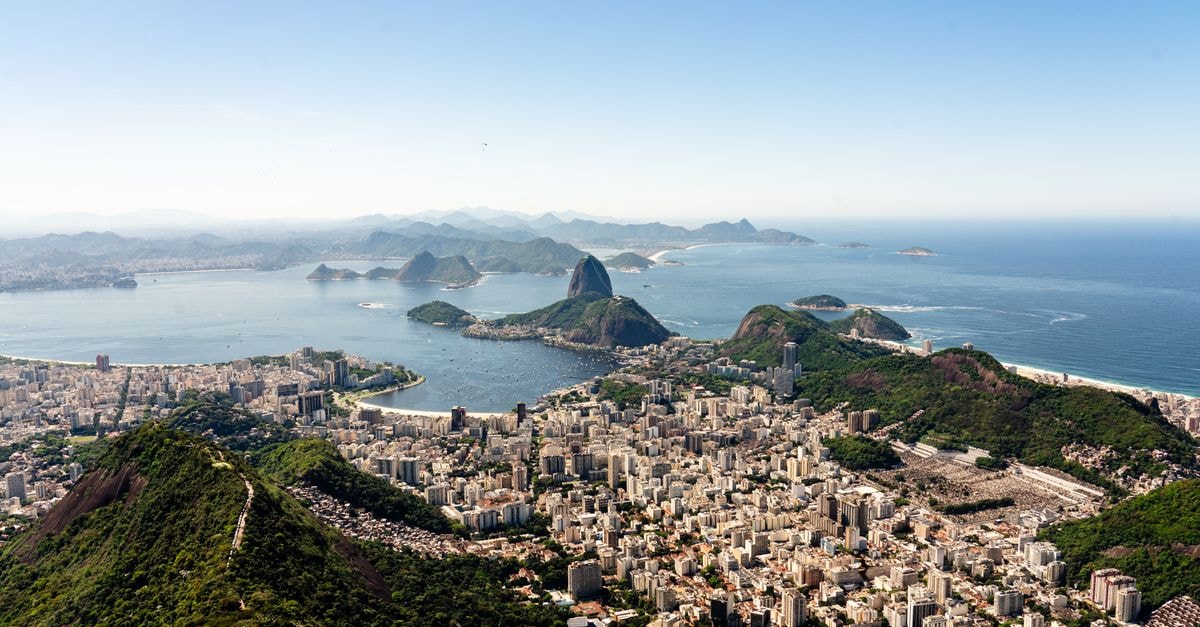 Go Inn Vitória in Vitória: A Practical Stay Near the Beach Stunning aerial view of Rio de Janeiro's cityscape with Sugarloaf Mountain and Guanabara Bay on a clear day.