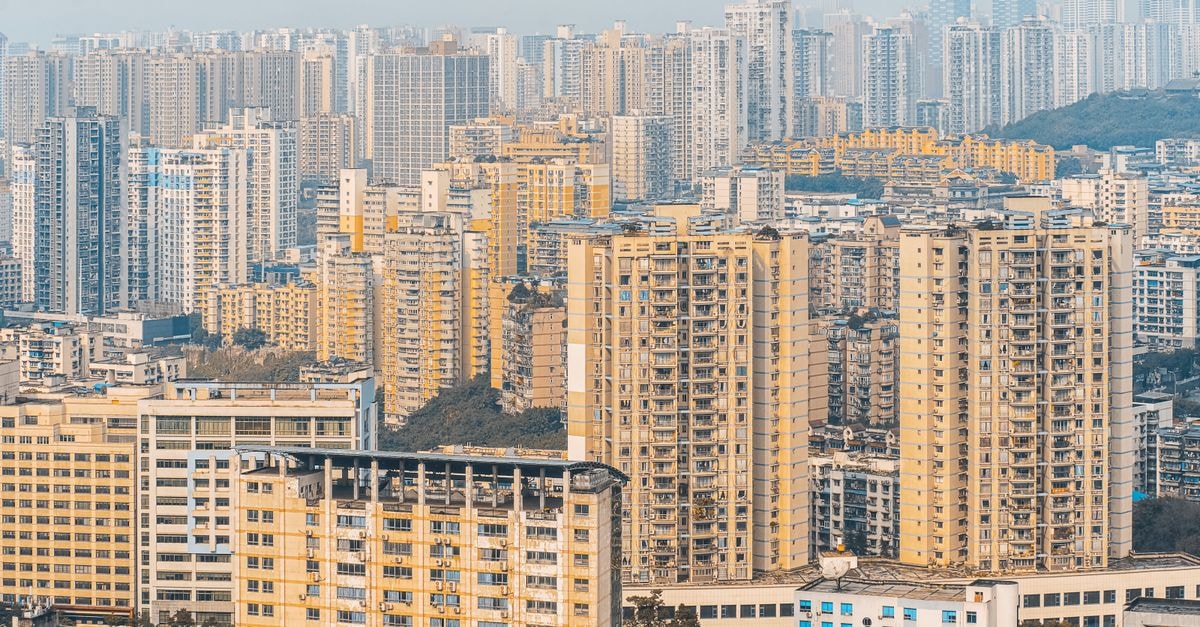 Harbour Plaza Resort City in Tin Shui Wai: A Resort-Style Retreat with Leisure Facilities An aerial view of a densely packed cityscape with numerous skyscrapers and residential buildings under a hazy sky.