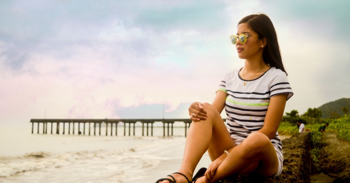 Salcedo Travel Guide: A Slow, Story-Filled Escape Young woman enjoying a serene moment by the seaside in Tanauan, Philippines.