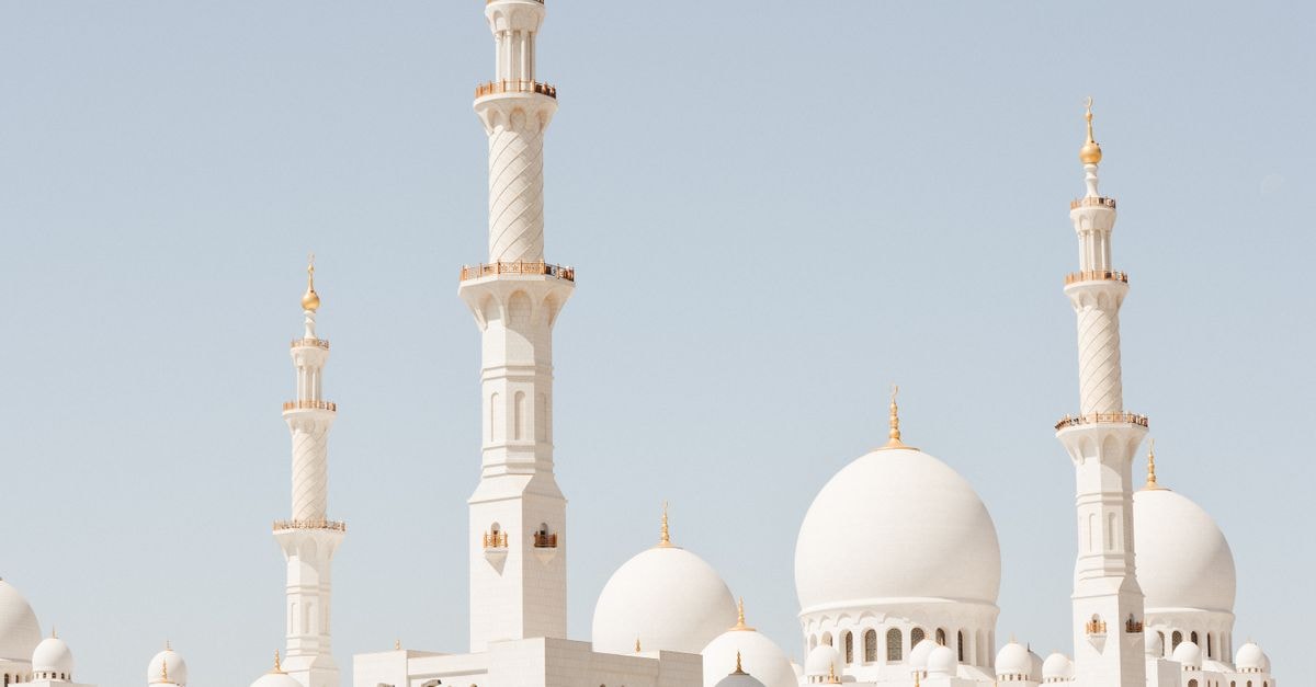 Majestic perspective of Sheikh Zayed Grand Mosque showcasing its domes and minarets under clear skies in Abu Dhabi.