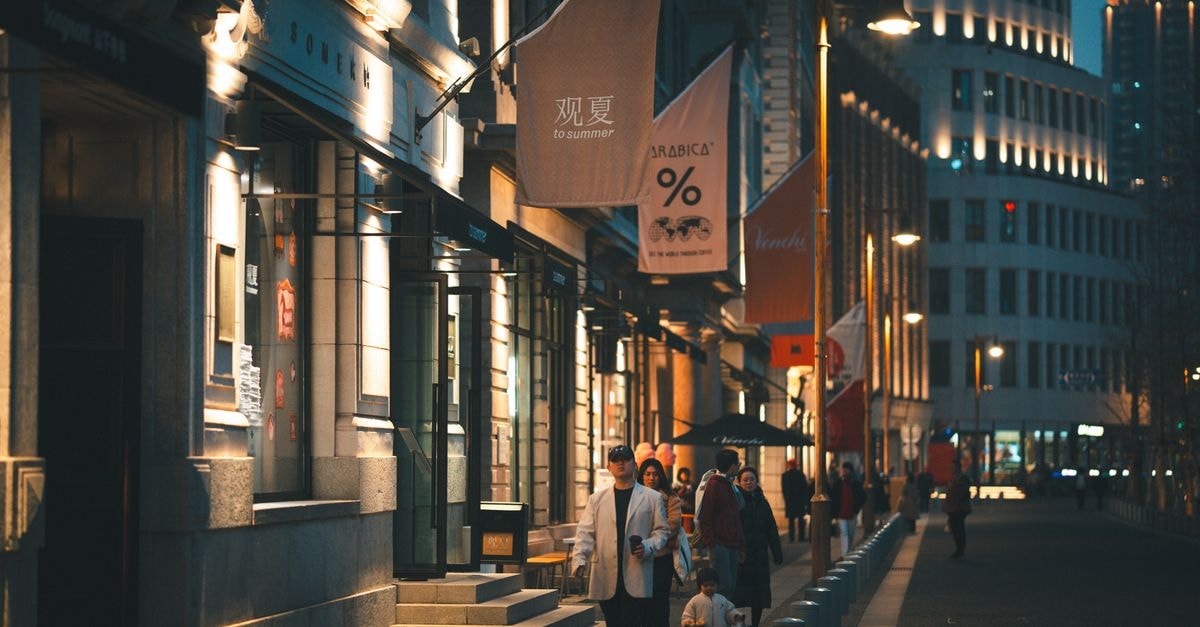 A Cinematic Walk Through Huangpu: A Shanghai Travel Guide People strolling through a bright, illuminated street at night in an urban area.