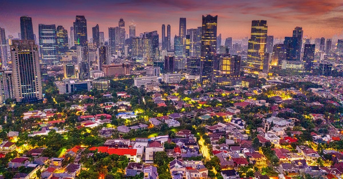 A breathtaking aerial view of Jakarta's skyline at twilight with vibrant city lights and towering skyscrapers.