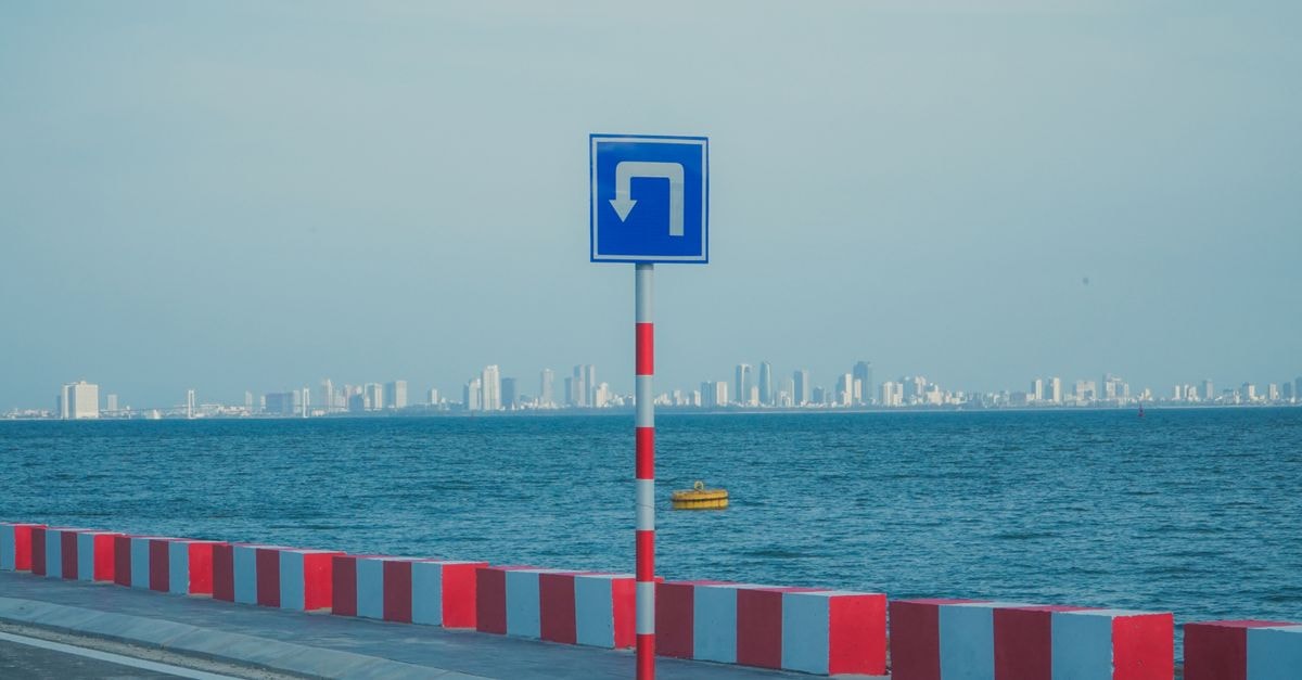 Manama Travel Guide: A Calm, Easygoing City by the Sea Coastal roadway with a turn sign against a city skyline in Da Nang, Vietnam.